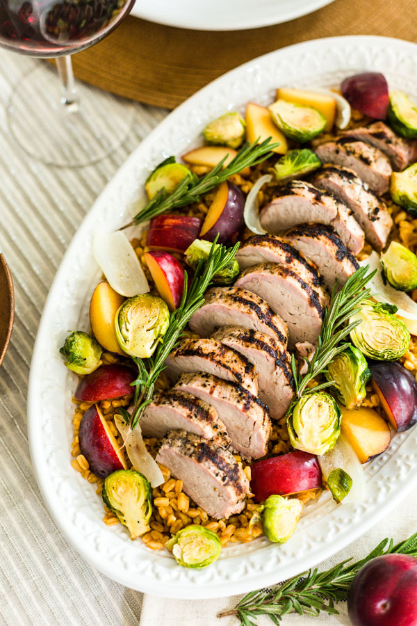 Enjoy the flavors of fall with this grilled pork loin, served over a bed of farro with roasted harvest vegetables and ripe plums.